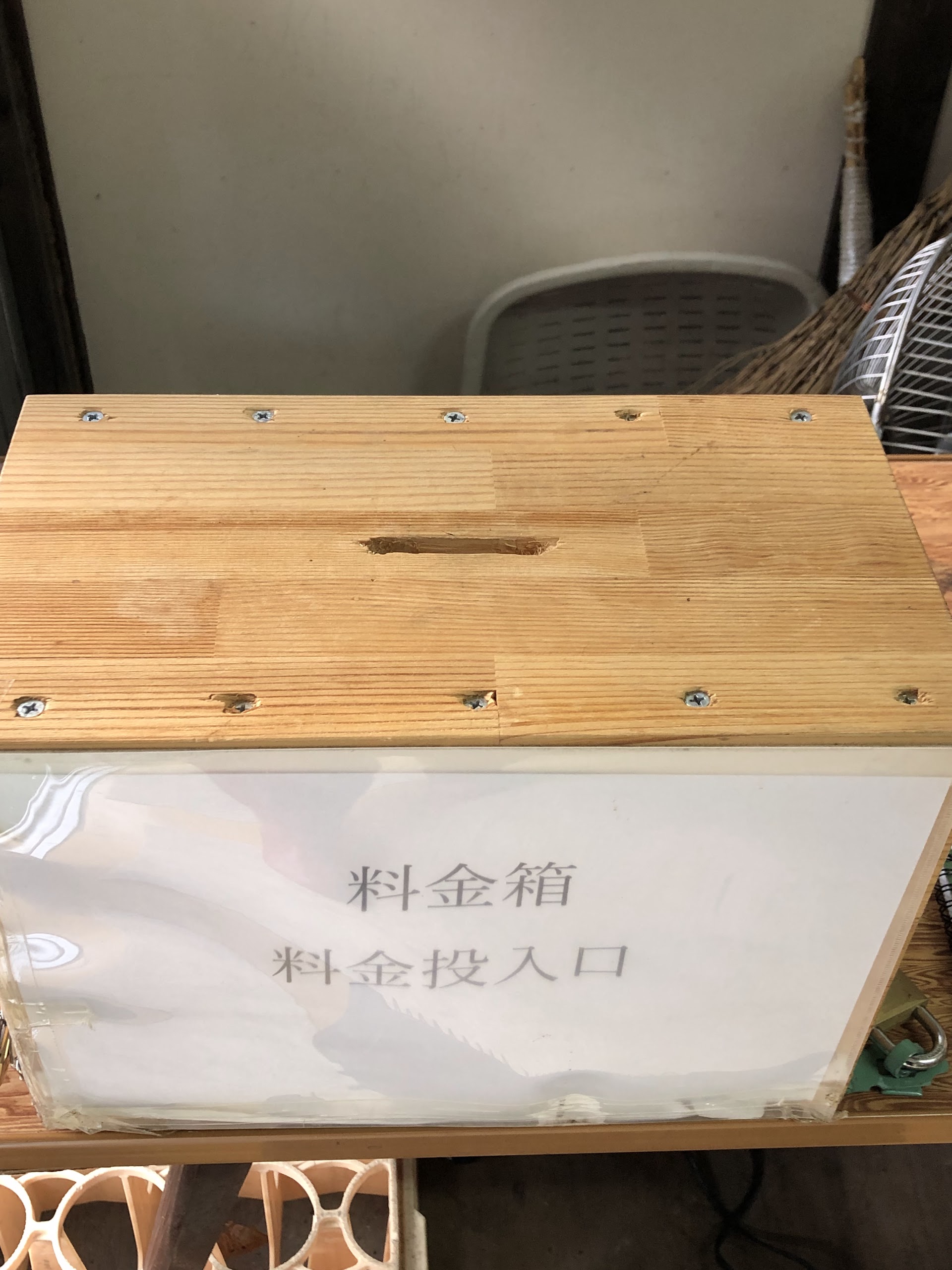 手作りの木の料金箱。「料金箱 料金投入口」と書かれている