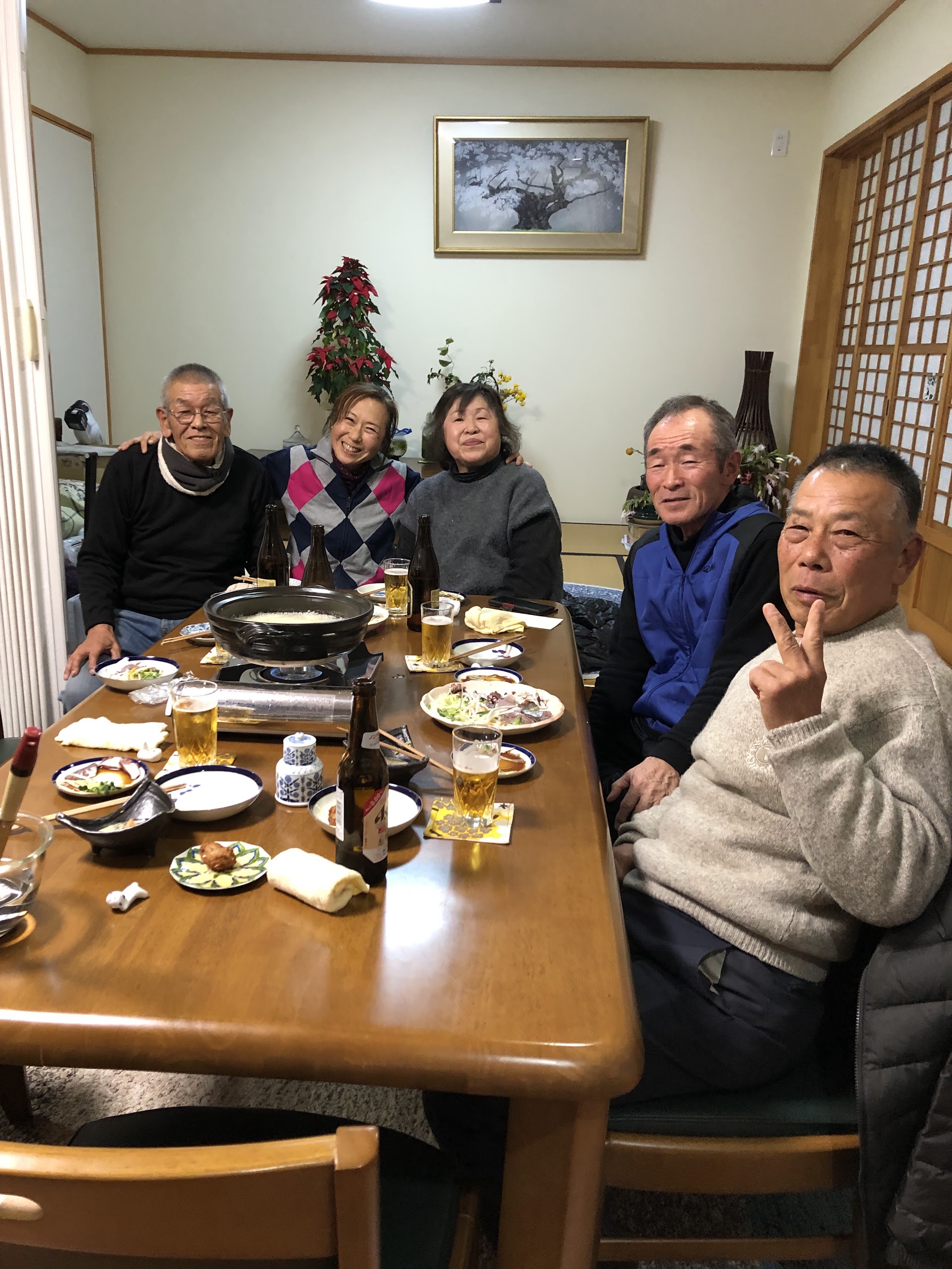 卓を囲んでみんなで食事会。鍋を前に笑顔で乾杯
